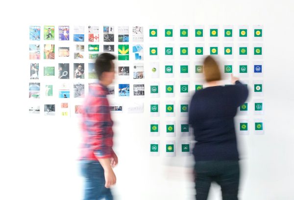 Designers developing a brand identity for a financial services client, working with logos, colour palettes, and strategy documents. Finance sector branding in action.